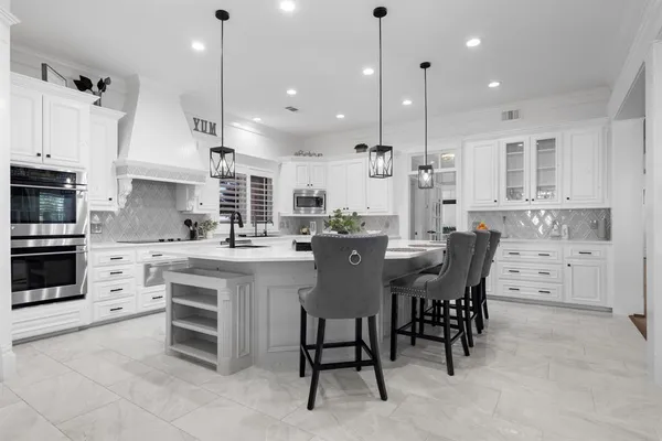a large kitchen with cabinets table and chairs