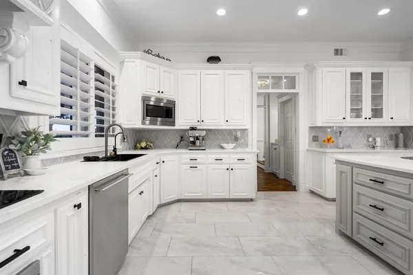 a kitchen with white cabinets and stainless steel appliances