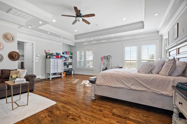 a spacious bedroom with a bed a couch and a chandelier