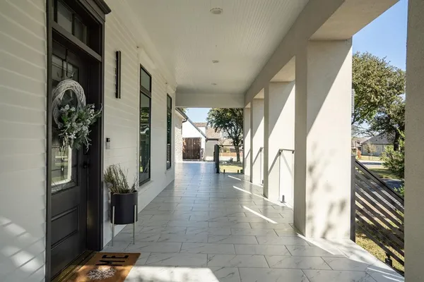 a view of a hallway with wooden floor and windows