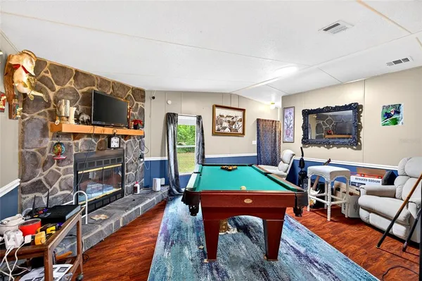a living room with furniture a flat screen tv and a pool table