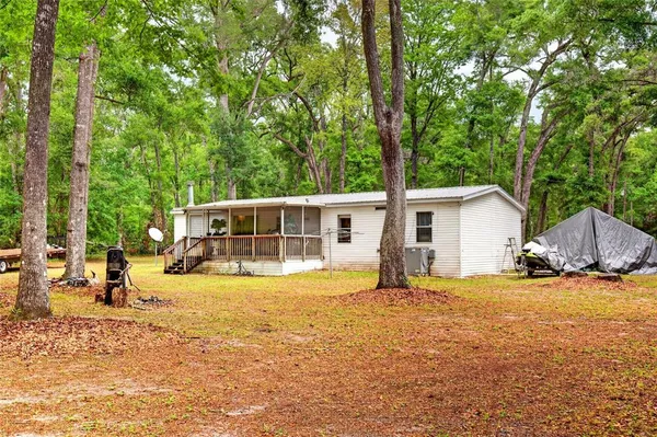 a view of a house with backyard and sitting area