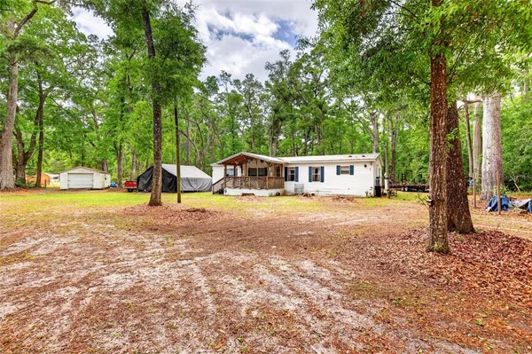 a view of a house with backyard and sitting area