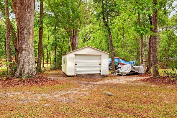 a view of a house with backyard and trees