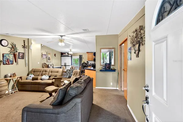 a living room with furniture and a kitchen view