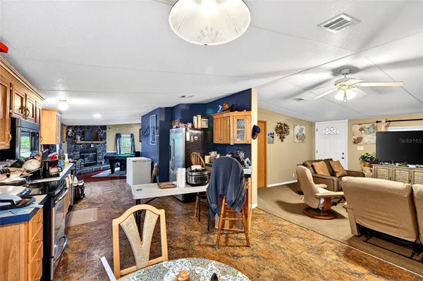 a living room with furniture kitchen view and a large window