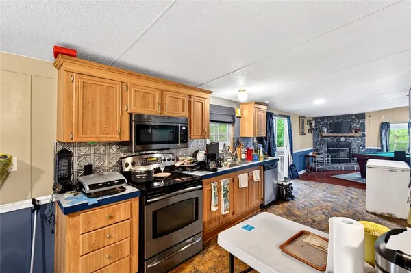 a kitchen with stainless steel appliances granite countertop a stove top oven a sink dishwasher and cabinets with wooden floor