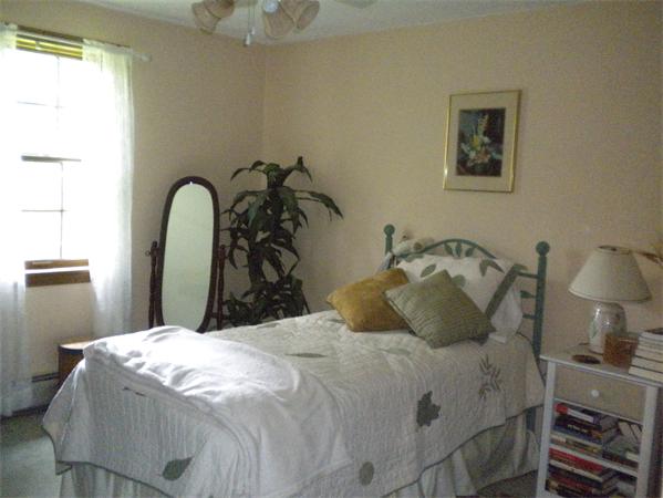 85 North Plain Road Sunderland, MA 01375 - Photo 12 of 13 a bedroom with a bed and a chandelier
