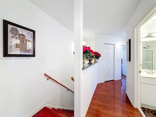 a view of a hallway with wooden floor and a workspace