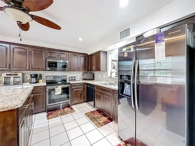 a kitchen with stainless steel appliances granite countertop a refrigerator stove top oven and sink
