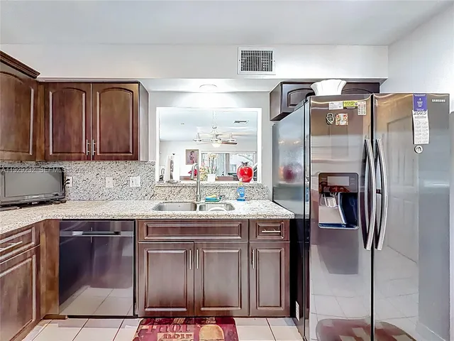a kitchen with stainless steel appliances granite countertop a refrigerator and a stove