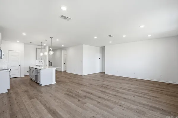 a view of kitchen with kitchen island stainless steel appliances cabinets and wooden floor