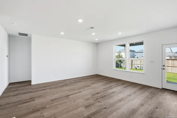 an empty room with wooden floor and window