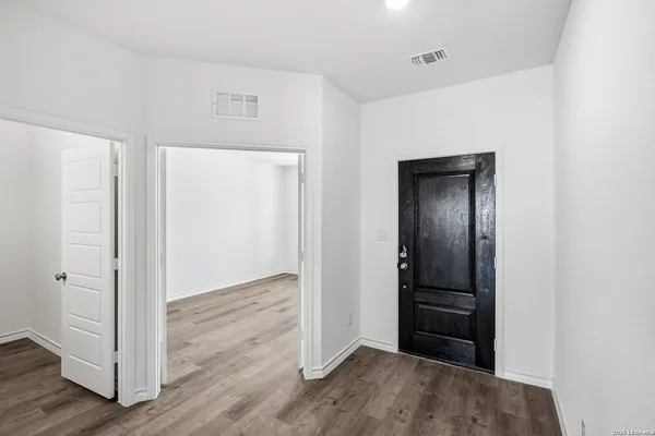 an empty room with wooden floor closet and gallery