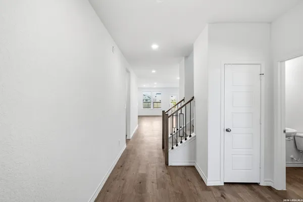 a view of hallway with stairs and wooden floor