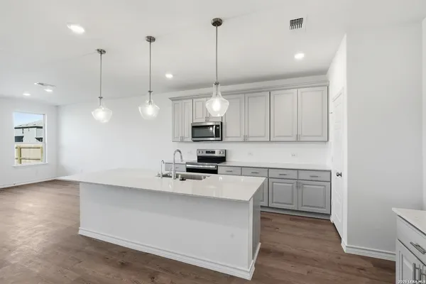 a kitchen with kitchen island a sink stainless steel appliances and cabinets