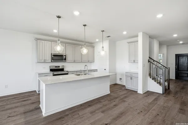 a kitchen with stainless steel appliances kitchen island granite countertop a stove a sink and a refrigerator