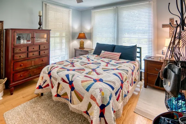 a bedroom with a bed and a dresser with the shoe rack