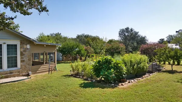 a backyard of a house with a garden and tree