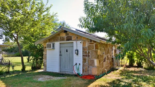 a view of a small house with wooden fence