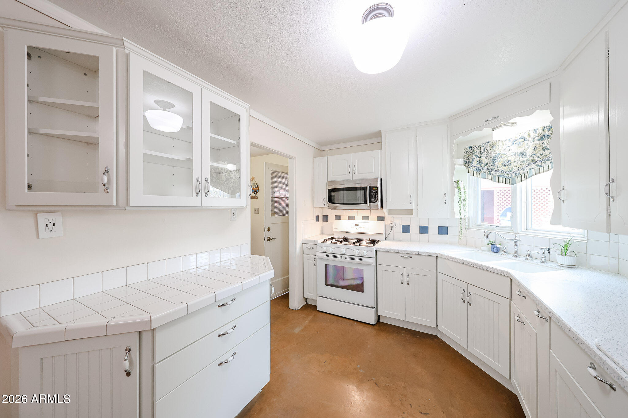 3108 North 21st Place Phoenix, AZ 85016 - Photo 16 of 56 a kitchen with white cabinets and white appliances