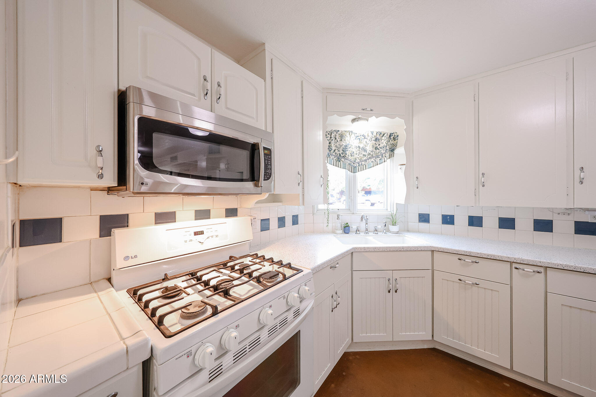 3108 North 21st Place Phoenix, AZ 85016 - Photo 17 of 56 a kitchen with cabinets appliances a sink and a window