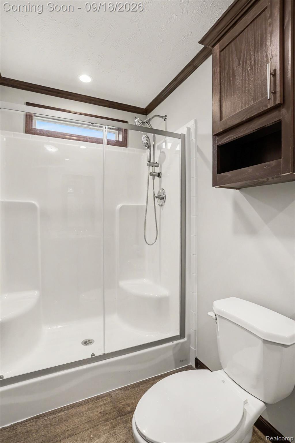 470 Flamingo Street Rochester, MI 48309 - Photo 10 of 17 Glass-enclosed shower with integrated seating, a compact toilet, wood-finish flooring, and crown molding