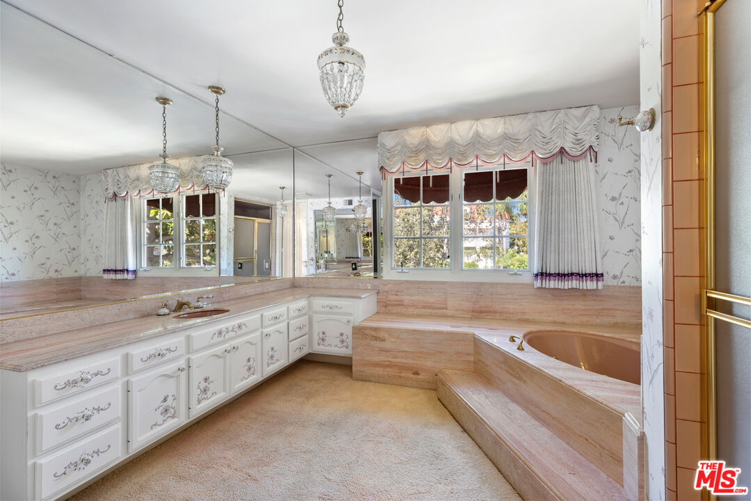 218 Foothill Road Beverly Hills, CA 90210 - Photo 11 of 16 a bathroom with a tub a sink and a large mirror