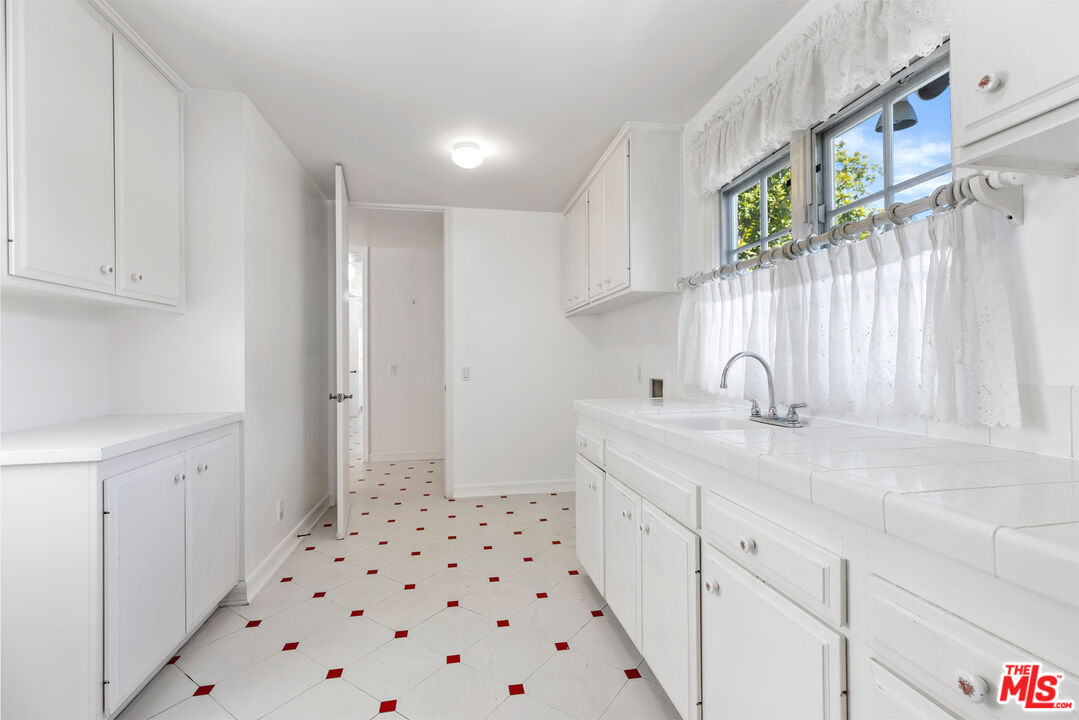 218 Foothill Road Beverly Hills, CA 90210 - Photo 8 of 16 a kitchen with a sink a stove cabinets and a window