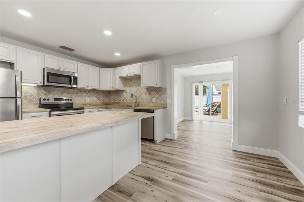 5340 Dartmouth Road New Port Richey, FL 34652 - Photo 14 of 41 a kitchen with kitchen island granite countertop a sink cabinets and stainless steel appliances
