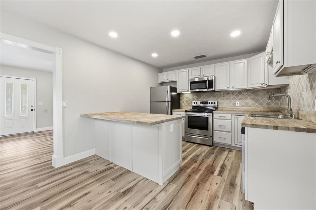 5340 Dartmouth Road New Port Richey, FL 34652 - Photo 15 of 41 a kitchen with stainless steel appliances granite countertop a stove a sink and a refrigerator