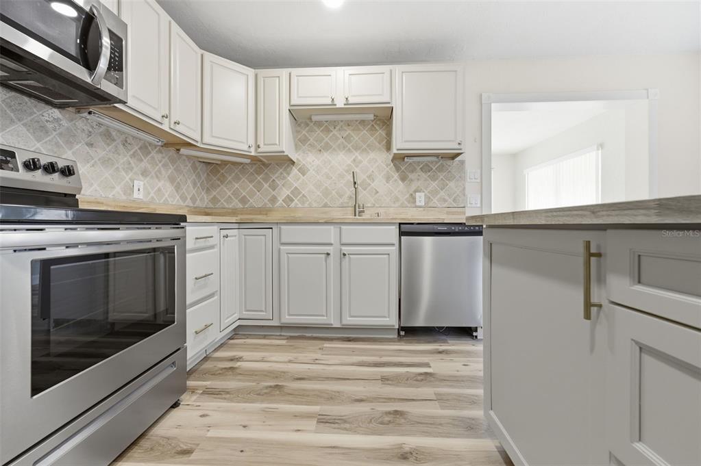 5340 Dartmouth Road New Port Richey, FL 34652 - Photo 17 of 41 a kitchen with stainless steel appliances granite countertop a stove and a microwave