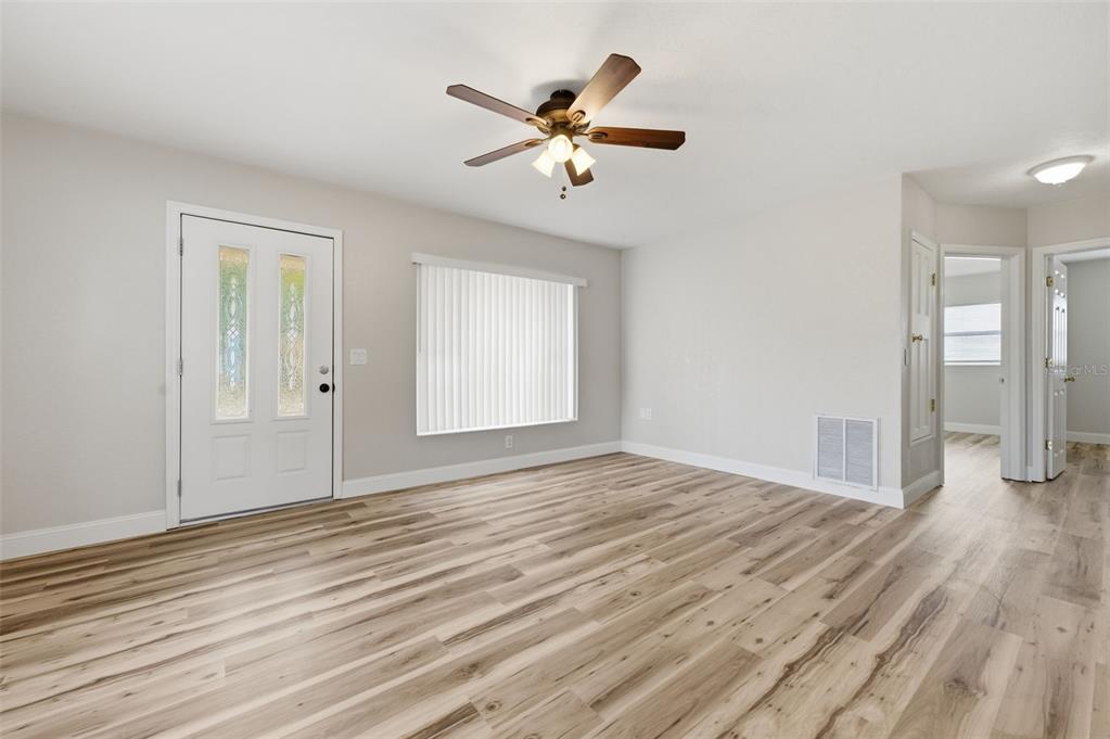 5340 Dartmouth Road New Port Richey, FL 34652 - Photo 25 of 41 a view of an empty room with wooden floor and a ceiling fan