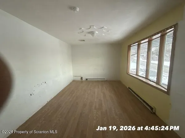 wooden floor in an empty room with a window