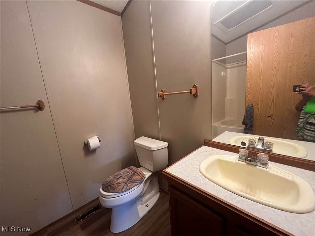 76303 Science Hill Road Kimbolton, OH 43749 - Photo 14 of 18 Full bathroom with vanity, toilet, hardwood / wood-style floors, and tub / shower combination