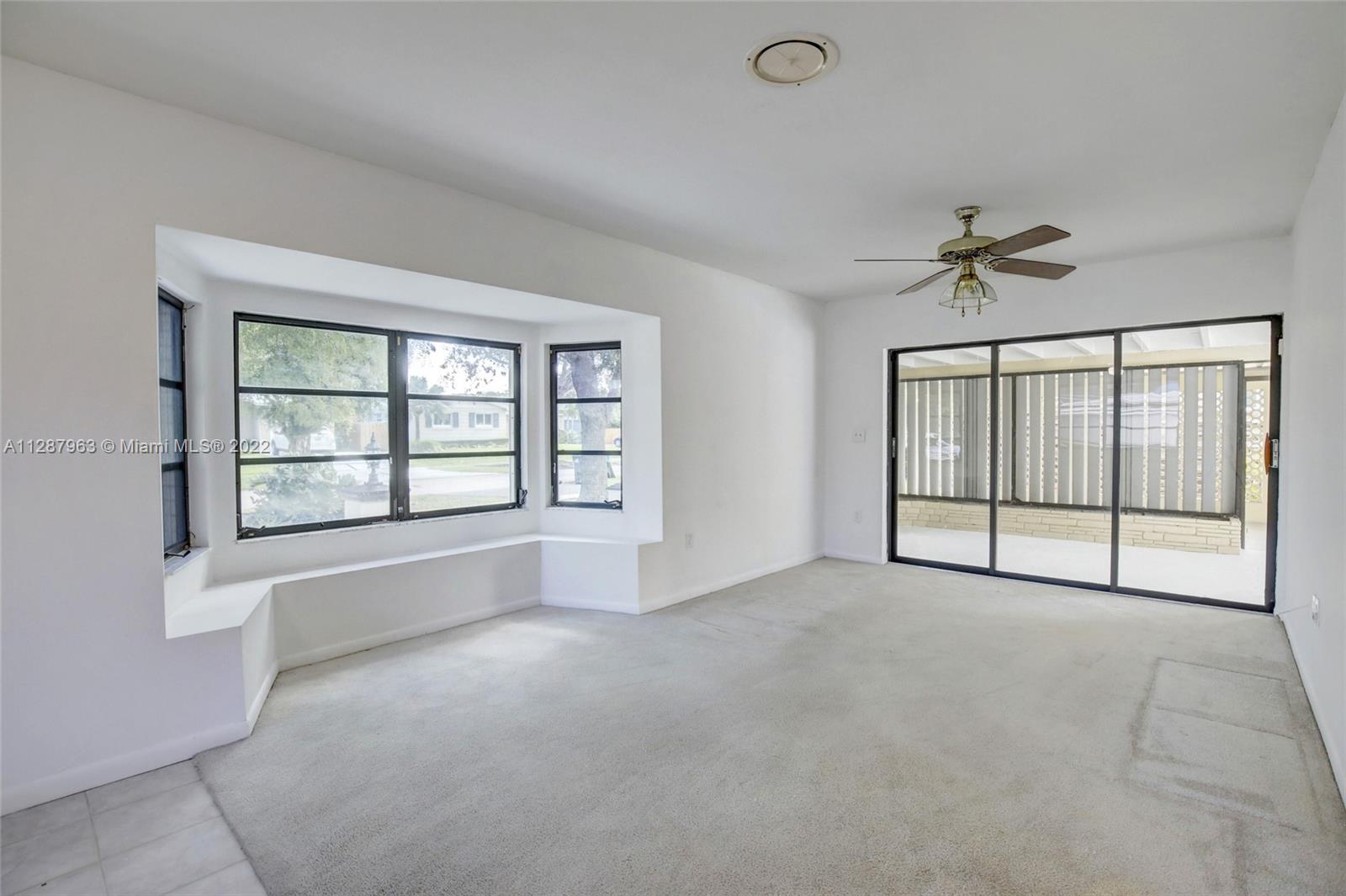 8751 Ridgeland Drive Cutler Bay, FL 33157 - Photo 13 of 26 an empty room with chandelier fan and windows