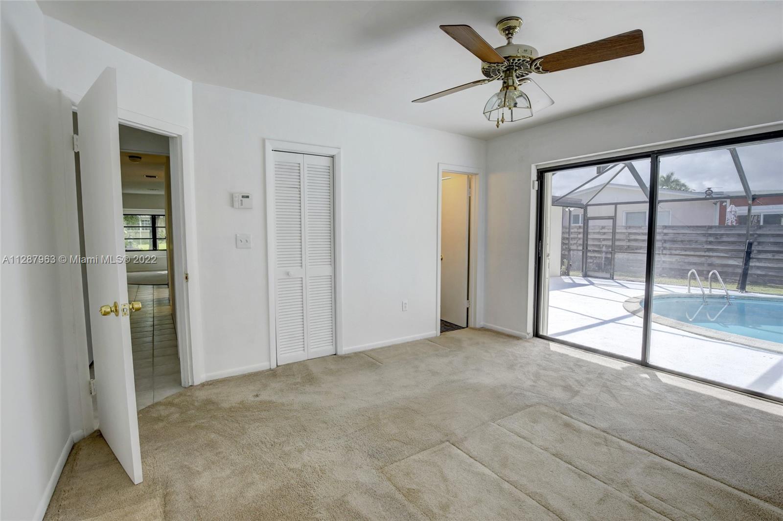 8751 Ridgeland Drive Cutler Bay, FL 33157 - Photo 14 of 26 an empty room with chandelier fan and windows