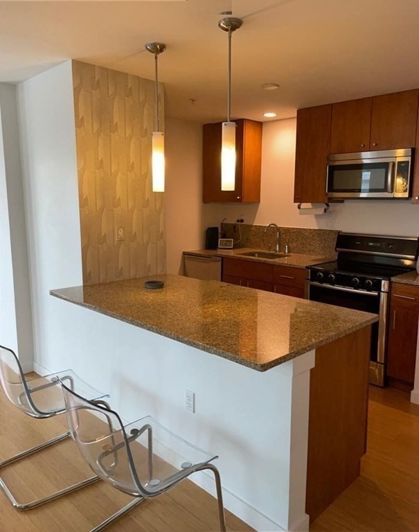 16 Miner Street, Unit 510 Boston, MA 02215 - Photo 21 of 26 a kitchen with stainless steel appliances granite countertop a sink a stove and a wooden floors