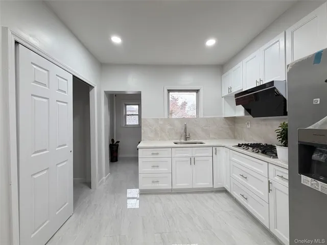 a kitchen with granite countertop white cabinets and black appliances