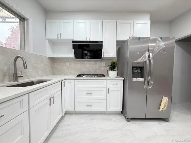 a kitchen with appliances a sink and cabinets