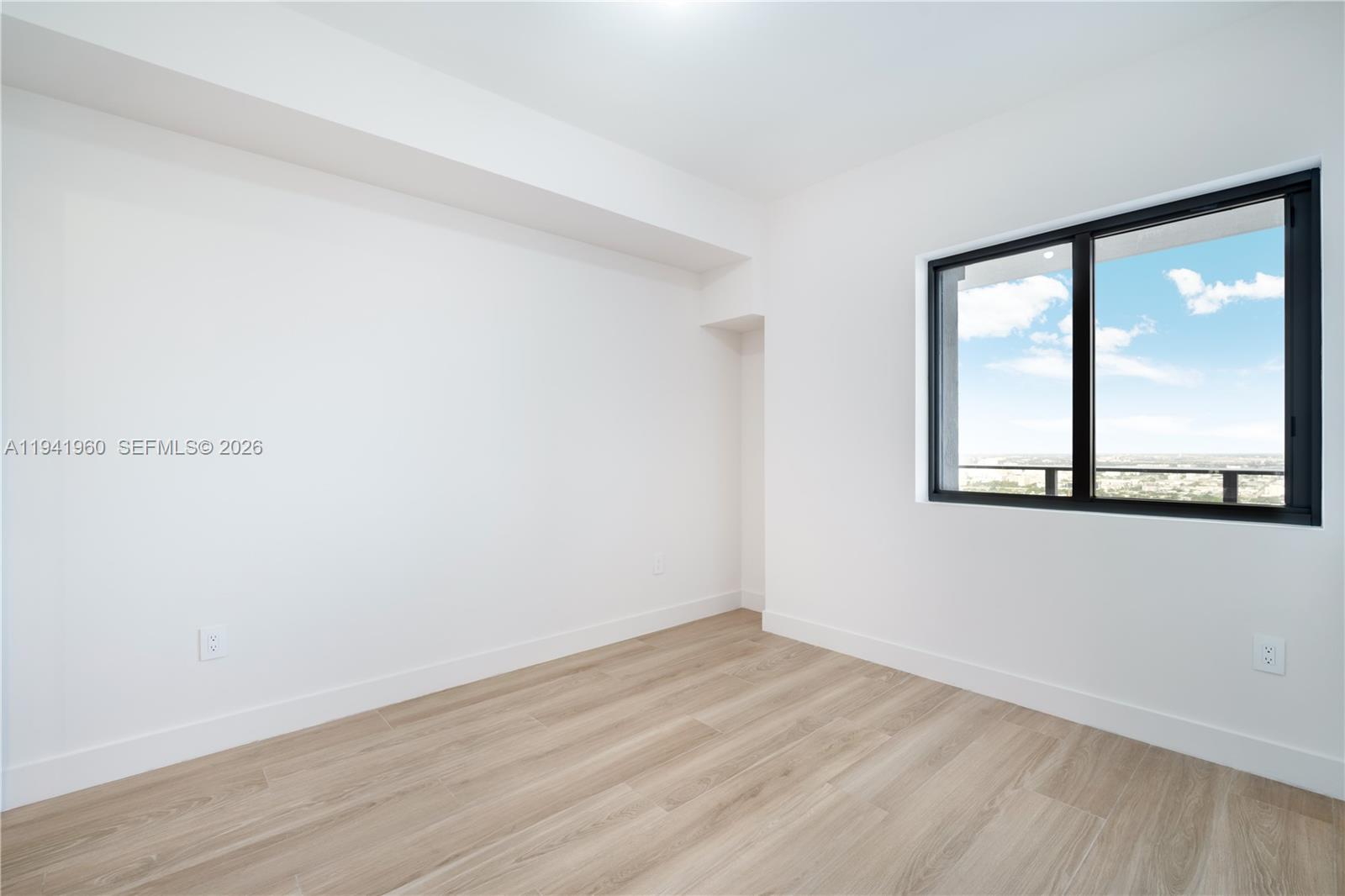 700 Northeast 24th Street, Unit 4203 Miami, FL 33137 - Photo 31 of 51 a view of an empty room with wooden floor and a window
