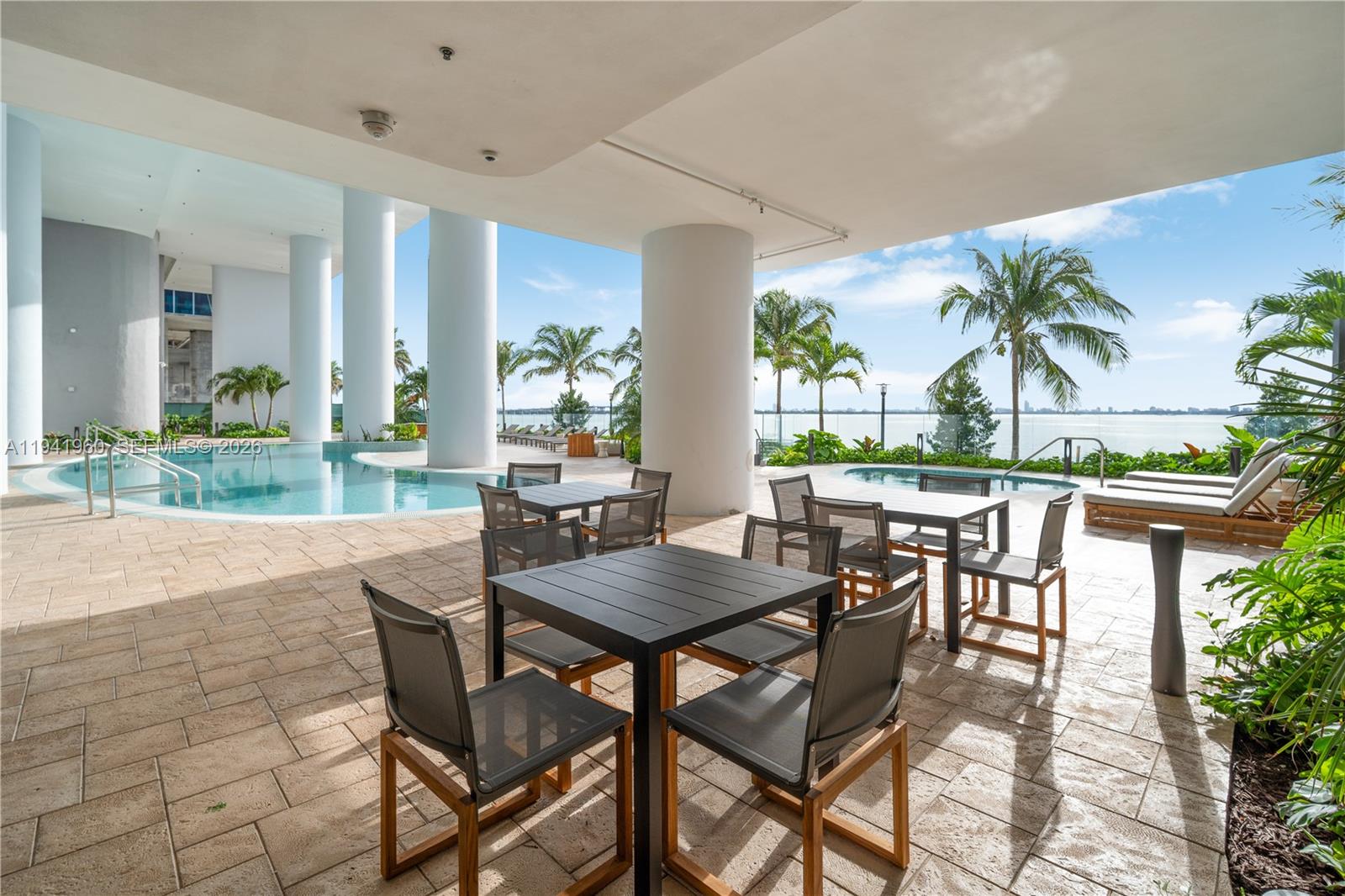 700 Northeast 24th Street, Unit 4203 Miami, FL 33137 - Photo 41 of 51 a view of a patio with table and chairs potted plants and palm tree
