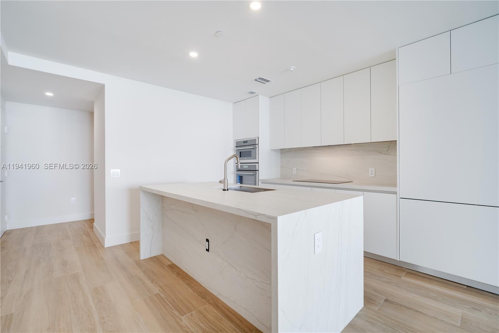 700 Northeast 24th Street, Unit 4203 Miami, FL 33137 - Photo 6 of 51 a kitchen with a sink cabinets and wooden floor