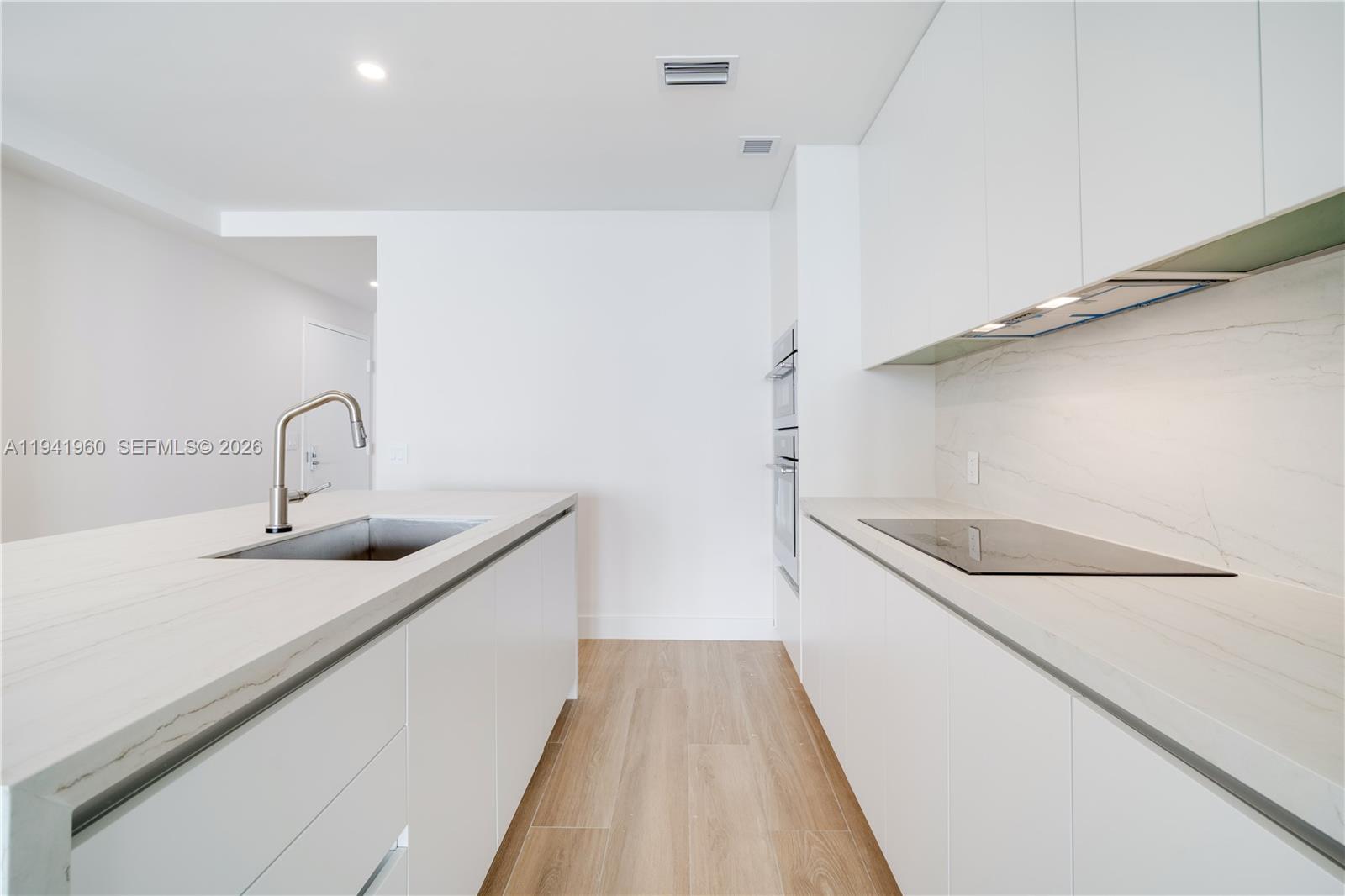 700 Northeast 24th Street, Unit 4203 Miami, FL 33137 - Photo 7 of 51 a kitchen with a sink and wooden floor