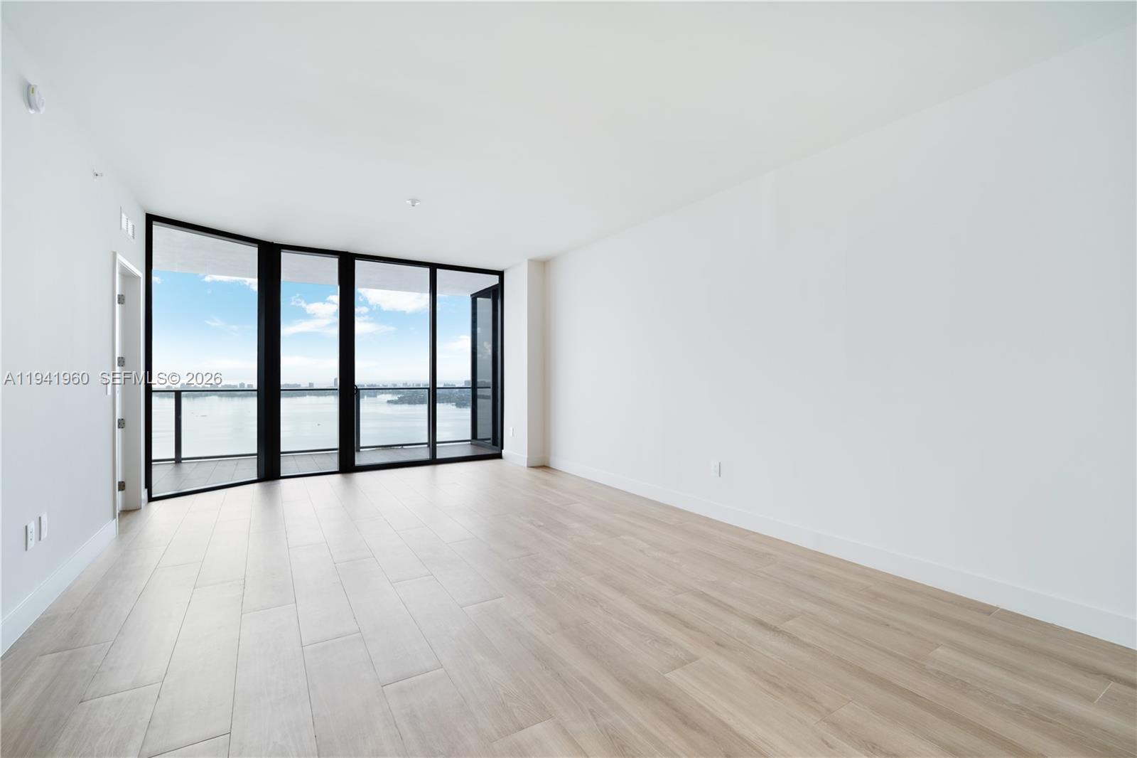 700 Northeast 24th Street, Unit 4203 Miami, FL 33137 - Photo 9 of 51 a view of an empty room with wooden floor and a window