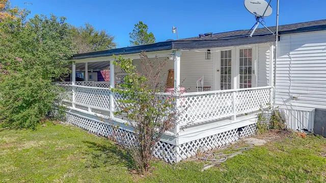 a view of a house with a small yard and wooden floor and fence