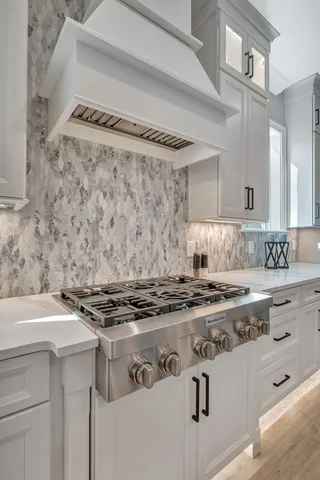 a kitchen with stainless steel appliances granite countertop a refrigerator a stove and a sink