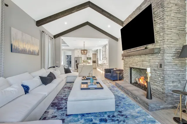 a living room with stainless steel appliances kitchen island furniture and a flat screen tv