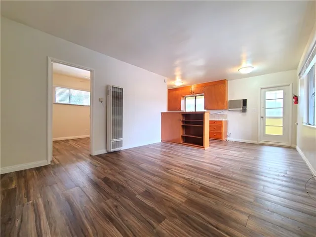 a view of a livingroom with wooden floor and furniture