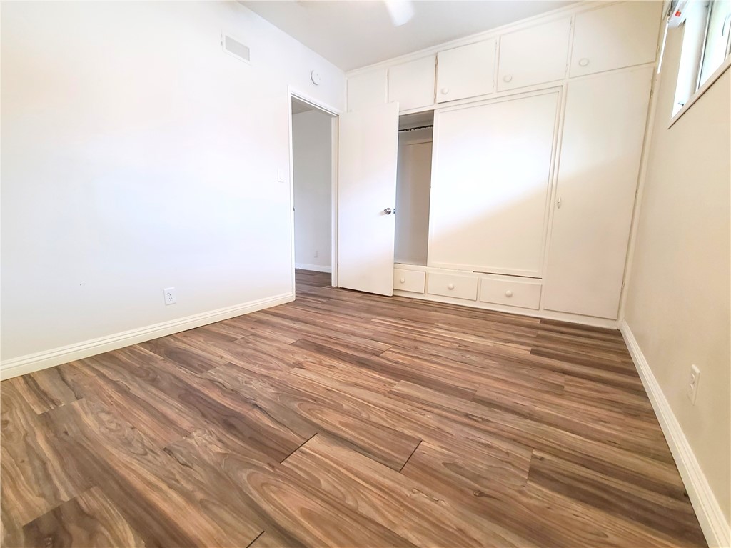 12 West Cypress Avenue Redlands, CA 92373 - Photo 8 of 10 an empty room with wooden floor and windows